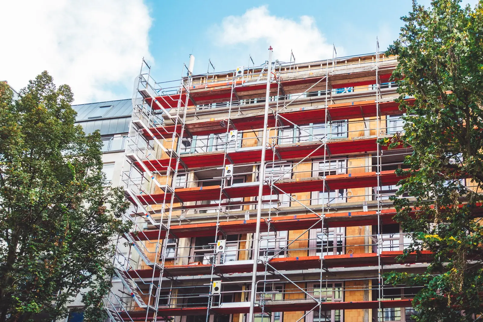 Mehrgeschossiges Wohnhaus mit umfangreichem Gerüst für sichere Fassadenarbeiten und den fachgerechten Zugang zu hohen Wänden